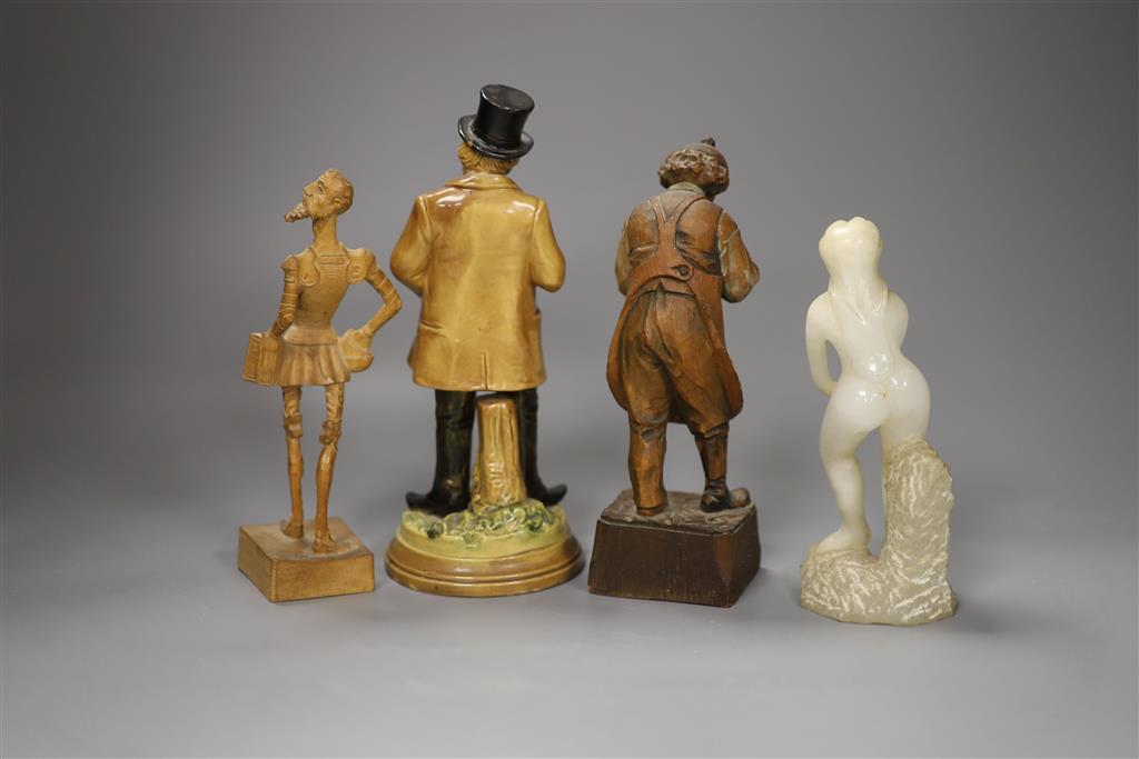 A German pottery figure and two alpine carved wood figures and a soapstone figure, tallest 21cm